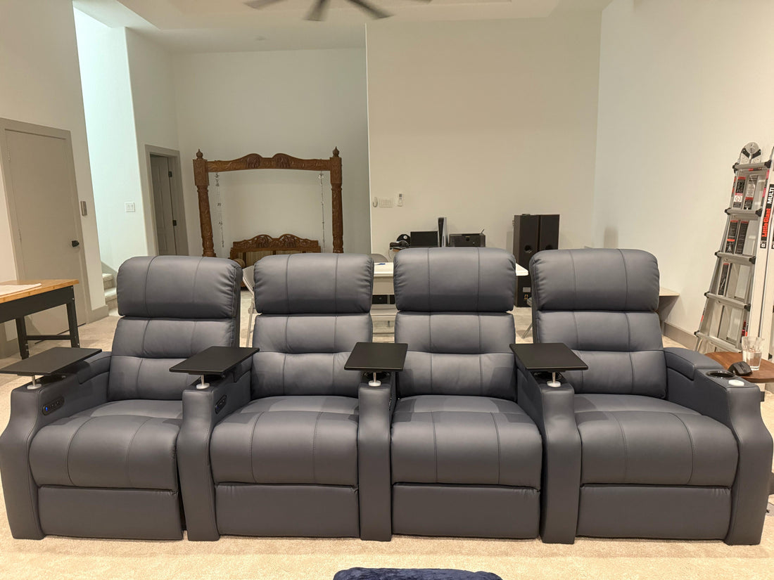 Four-seat gray leather home theater recliner sofa with padded headrests and cup holders in a living room